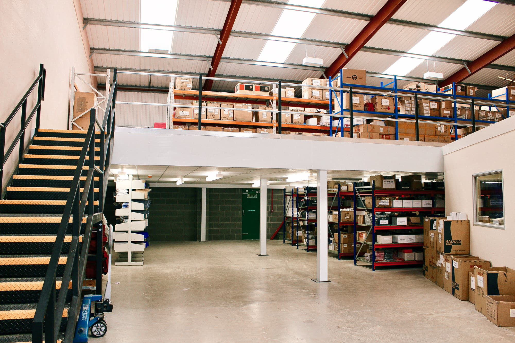 Warehouse mezzanine with sturdy hand railing, organized shelving, and ample storage space for efficient inventory management.