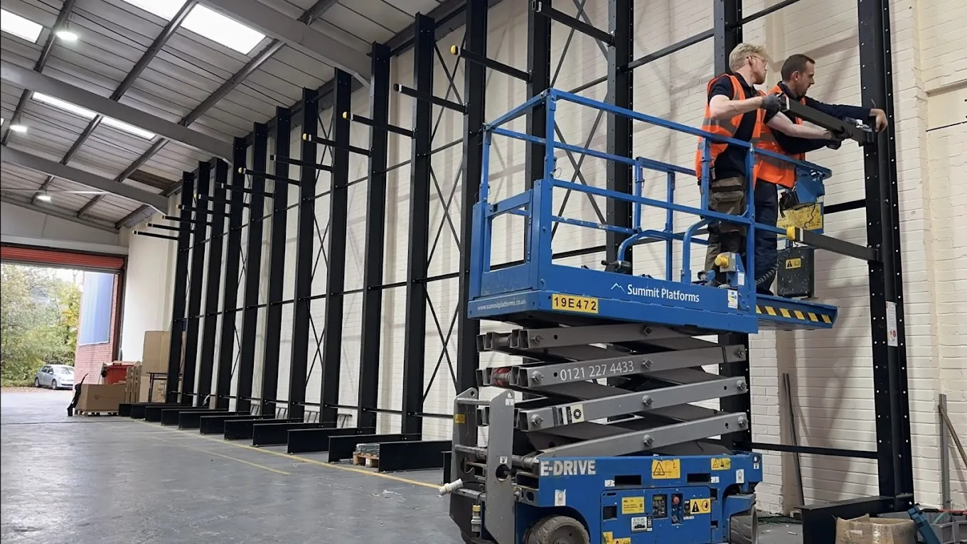 Two RJ workspace contractors using a scissor lift to install and heavy duty cantilever rack in Dudley 