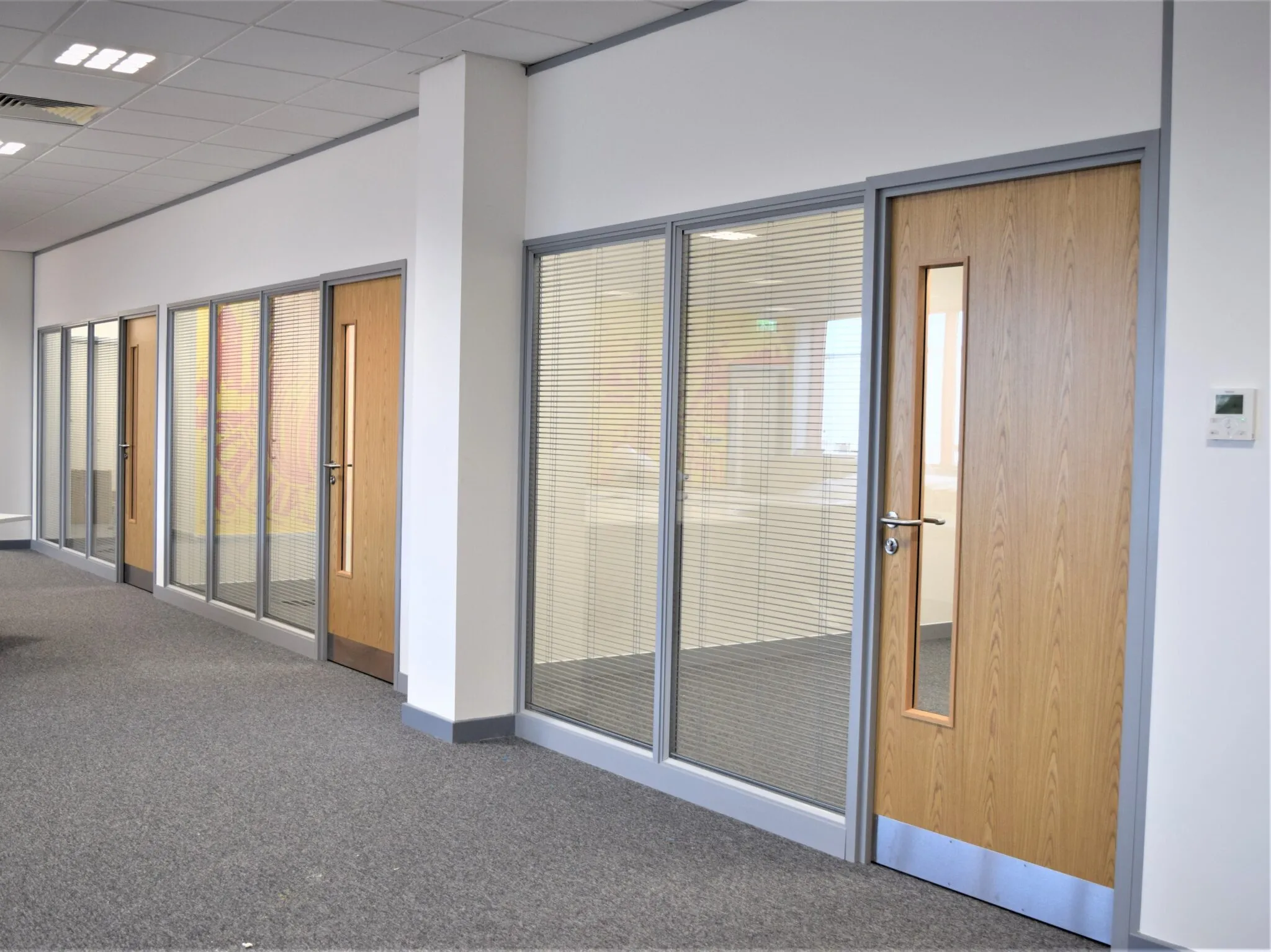 Glass and Plasterboard office partitioning installation with high suspended ceiling and vison panel door in Market Drayton